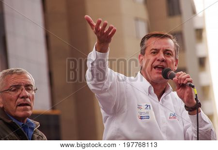 Quito, Ecuador - April 7, 2016: Closeup opposition leader Andres Paez talking with a microphone and surrounded by people and journalists during anti government protests in Shyris Avenue.