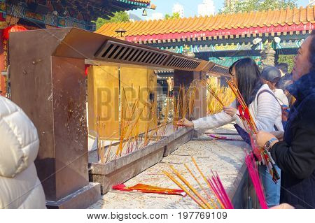 HONG KONG, CHINA - JANUARY 22, 2017: Unidentified people burning incenses inside of Wong Tai Sin Buddhist Temple to pray, in Hong Kong, China.