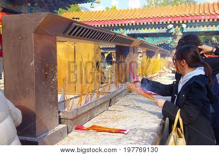 HONG KONG, CHINA - JANUARY 22, 2017: Unidentified people burning incenses inside of Wong Tai Sin Buddhist Temple to pray, in Hong Kong, China.
