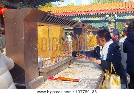HONG KONG, CHINA - JANUARY 22, 2017: Unidentified people burning incenses inside of Wong Tai Sin Buddhist Temple to pray, in Hong Kong, China.