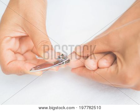 Closeup attractive young woman cutting her feet nails. Health care and beauty concept.