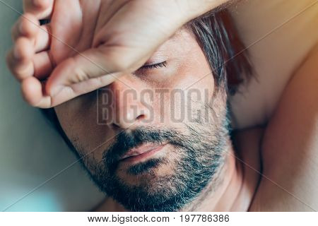 Adult caucasian man sleeping in bed top view of naked male person with his head on the pillow in the morning