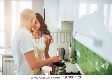 Happy young couple preparing on the stove.