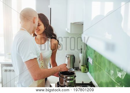Happy young couple preparing on the stove.