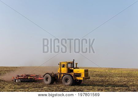 Farmer in tractor preparing land with seedbed cultivator