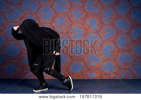 Young dancer dancing near the wall. Urban style