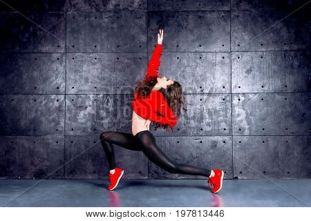 Girl dancing in front of the urban wall.