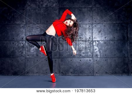 Girl dancing in front of the urban wall.