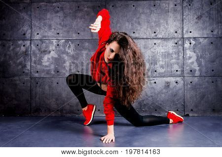 Girl dancing in front of the urban wall.