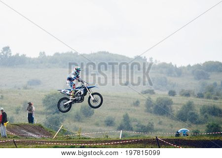 Osinniki RUSSIA - July 28 2017: Open competitions in motocross and motorcycle races off-road cross-country. team of athletes on mountain bikes jump.