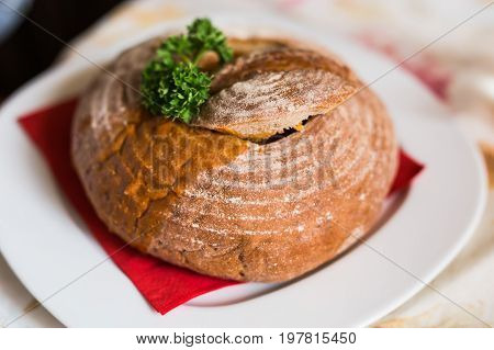 Goulash soup in bread served in a bread bowl.