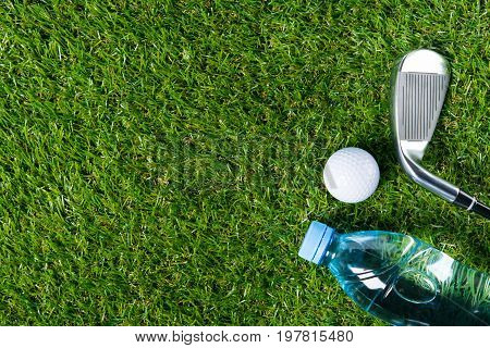 On a green lawn set for playing golf and a bottle of water there is a place for an inscription