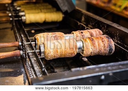 Trdelnik - traditional national czech street desert, baking on the street of Prague.