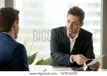 Financial adviser consulting businessman, holding paper, explaining contract terms or investment plan, bank worker helping client with document, salesman proposing good deal to customer, making offer