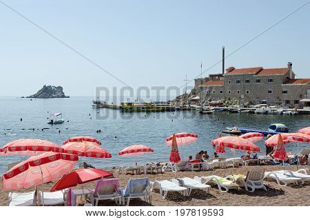PETROVAC MONTENEGRO - SEPTEMBER 19 2015: Unknown people rest on beach in popular resort town of Petrovac near old Venetian fortress Montenegro