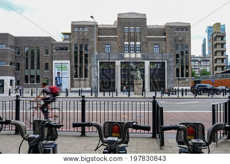 Poplar London UK - July 16 2017: Poplar Baths regenerated looking from Chrisp Street with Boris bikes in the foreground.