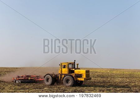 Farmer in tractor preparing land with seedbed cultivator