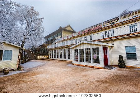 Huangshan mountain China - December 27 2016: Exterior of the four star Pai Yun Lou hotel at foggy cold winter day time.