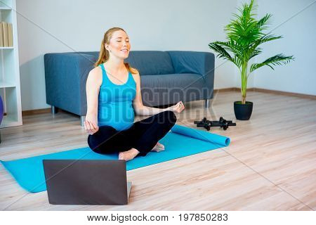 Pregnant woman doing yoga stretching at home