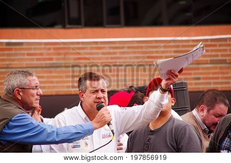 Quito, Ecuador - April 7, 2016: Closeup opposition leader Andres Paez surrounded by people and holding in his hands proofs of election fraud, police and journalists during anti government protests in Shyris Avenue.