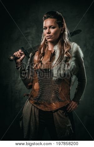 Viking woman with cold weapon in a traditional warrior clothes