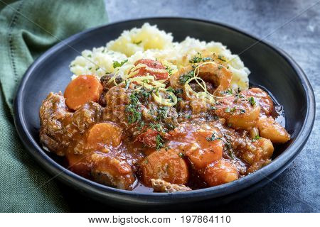 Osso bucco beef stew with potato mash.  Garnished with lemon zest and parsley.