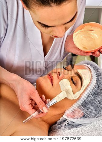 Collagen face mask. Facial skin treatment. Face of woman of elderly woman 50-60 years old receiving cosmetic procedure in beauty salon close up. Mask against sagging skin. Removing wrinkles.