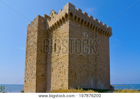 a view of the medieval fortified monastery of the Lerins Abbey in the Saint-Honorat island, France, surrounded by the Mediterranean sea