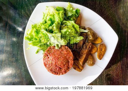 Raw beef classic steak tartare on white plate