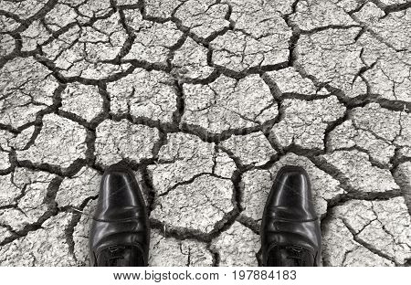 a salaman shoes standing on dry arid oil ground. in another mean as who had a barrier crisis time or difficult troble concept.