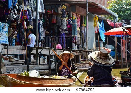 Bangkok / Thailand - January 20 2017: Thai women working in a boat in the floating market nearby Bangkok. Floating market is one of the main tourists attractions in Bangkok.
