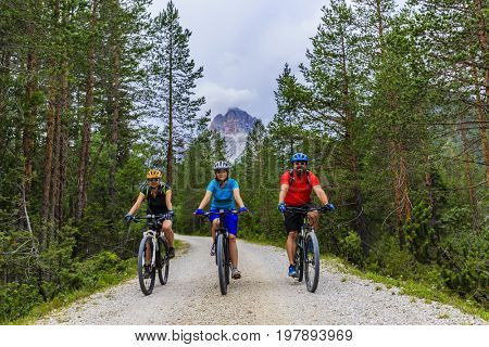 Mountain biking family with bikes on track, Cortina d'Ampezzo, Dolomites, Italy