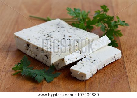 Block Of Natural Tofu With Herbs, Two Tofu Slices And Fresh Parsley  On Wooden Chopping Board.