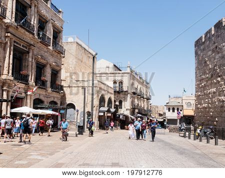 Jerusalem Israel July 14 2017 : Tourists walk along the Omar Ben el-Hatab street near the Jaffa Gates and watch the sights in the old city of Jerusalem Israel.