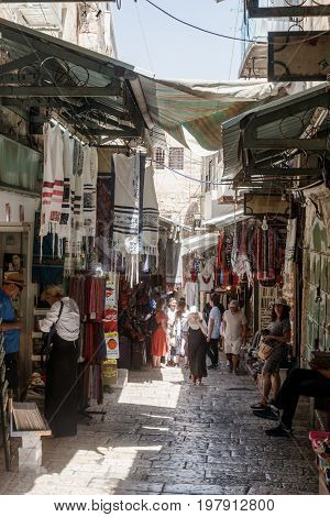Jerusalem Israel July 14 2017 : Tourists walk through the bazaar along David Street and look at souvenirs near to Jaffa Gate in the old city of Jerusalem Israel.