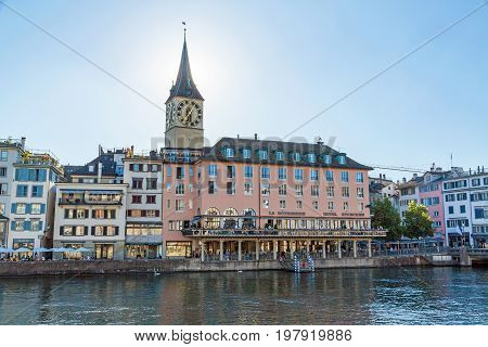 Zurich Switzerland - June 10 2017: Hotel Storchen at promenade Limmatquai church Saint Peter in background