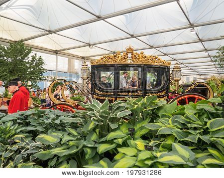 LONDON UK - MAY 25 2017: RHS Chelsea Flower Show 2017. Visitors observing the Australian State Coach standing near the Bowdens hostas in the Great Pavilion.