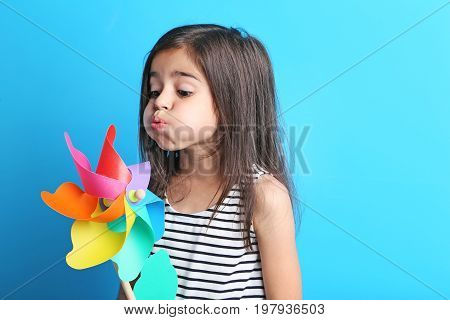 Beautiful Little Girl With Rainbow Whirligig On Blue Background