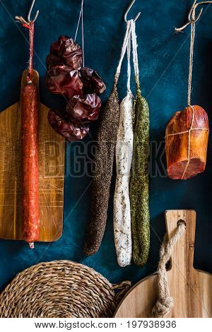 Variety of traditional Spanish charcuterie meat sausages towel wood cutting board rustic kitchen interior