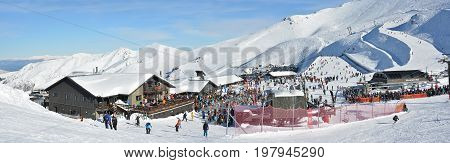 Mount Hutt New Zealand - July 30 2017: Panoramic view of the Mount Hutt Ski Field at Lunch Time. Skiers prepare to ride on the Chairlift outside the restaurant Canterbury New Zealand.