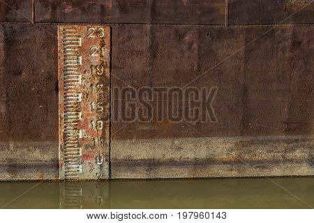 Depth Marker Printed Onto The Side Of Old Cargo Ship