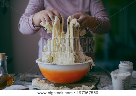 Close Up View Of Baker Kneading Dough. Homemade Bread. Hands Preparing Bread Dough On Wooden Table.