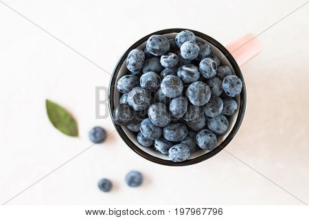 Sweet Blueberry In Cup With Leaf On White Table.
