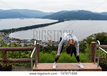 Woman viewing the landscape upside down in Amanohashidate in Kyoto