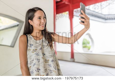 Woman taking selfie in chinese garden