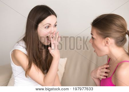 Exited woman showing engagement ring to her close girlfriend who feeling astonished because of unexpected surprise. Happy attractive lady boasting about getting new precious expensive ring on finger
