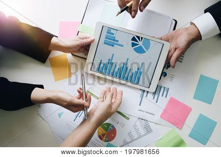 Business team hands at working with financial plan meeting discussion brainstrom with tablet on office desk Top view shot.