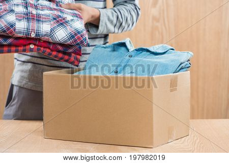Donation box for poor with clothing in male hands