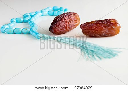 Two Fresh Dates Medjool And Rosary On White Table Background. Copy Space.