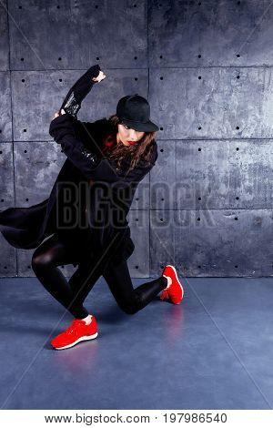 Girl dancing in front of the urban wall.